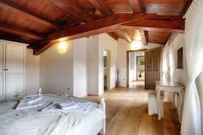 A bedroom with a wooden ceiling, a bed with white linens, a small table, and a chair. - Holiday Home in Golas With Private Pool (Bale)