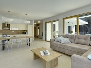 Relax in a spacious living area with a comfortable sofa and coffee table, and enjoy views of the surrounding area from large windows.