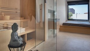 A modern room with a glass partition, a wooden bench, a statue, and a large window with a view of buildings. - Villa in Vodnjan With Garden (Vodnjan)