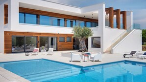 A modern two-story house with a swimming pool, outdoor seating, and a staircase leading to the upper level. - Villa in Vodnjan With Garden (Vodnjan)