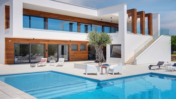 A modern two-story house with a swimming pool, outdoor seating, and a staircase leading to the upper level. - Villa in Vodnjan With Garden (Vodnjan)