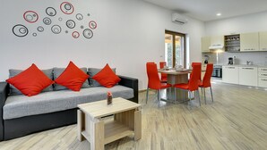 A modern living room with a grey sofa, red cushions, and a wooden coffee table. - Detached Modern Villa With Pool and Fenced Yard Near the Sea (Liznjan)