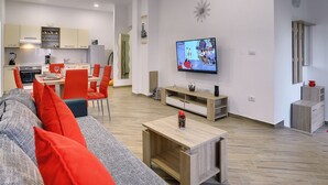 A modern living room with a sofa, a TV, and a dining area with chairs and a table. - Detached Modern Villa With Pool and Fenced Yard Near the Sea (Liznjan)