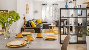 A modern living room with a dining area, featuring a sofa, a coffee table, and a bookshelf. - Detached Holiday Home With Swimming Pool, Near the Beach (Marcana)