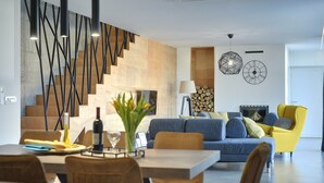 A modern living room with a staircase, a dining area, and a sofa set. - Villa in Liznjan With Pool Near the Beach (Liznjan)