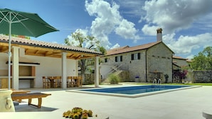 A stone house with a swimming pool, outdoor seating, and a covered patio area. - Holiday Home in Rojnici With Private Pool (Barban)
