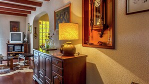 Une chambre traditionnelle, meublée de meubles en bois, avec une horloge ancienne et un téléviseur.