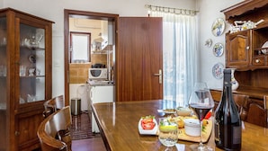 Une cuisine compacte avec des meubles en bois, une table à manger pour deux personnes et un four à micro-ondes.