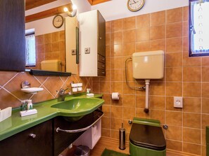 A bathroom with a green sink, a toilet, and a mirror. - Holiday Home in Pula Near Crystal Clear Sea (Pula)