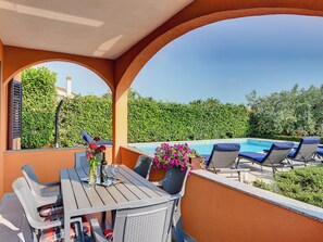 An outdoor seating area with a pool, surrounded by greenery and a clear sky. - Detached 6 Bedroom House with Private Pool near Ližnjan (Liznjan)