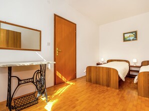 A hotel room with a wooden floor, a bed, a desk with a mirror, and a painting on the wall. - Detached 6 Bedroom House with Private Pool near Ližnjan (Liznjan)