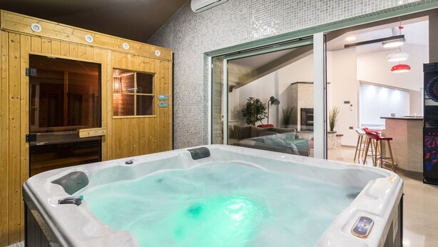 Ein Whirlpool in einem Raum mit Holzwänden und Fliesenboden.