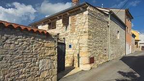 Una calle estrecha con edificios de piedra, uno de los cuales muestra el número '920'.