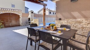An outdoor patio with a stone wall, a pool, and a stone oven. - Modern Holiday Home With Swimming Pool, Terrace With Bbq, Near the Center of Pula (Pula)