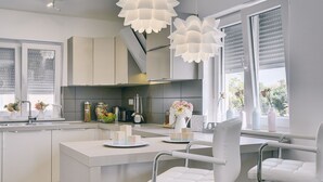 Una cocina moderna con una isla central, taburetes de bar e iluminación colgante.