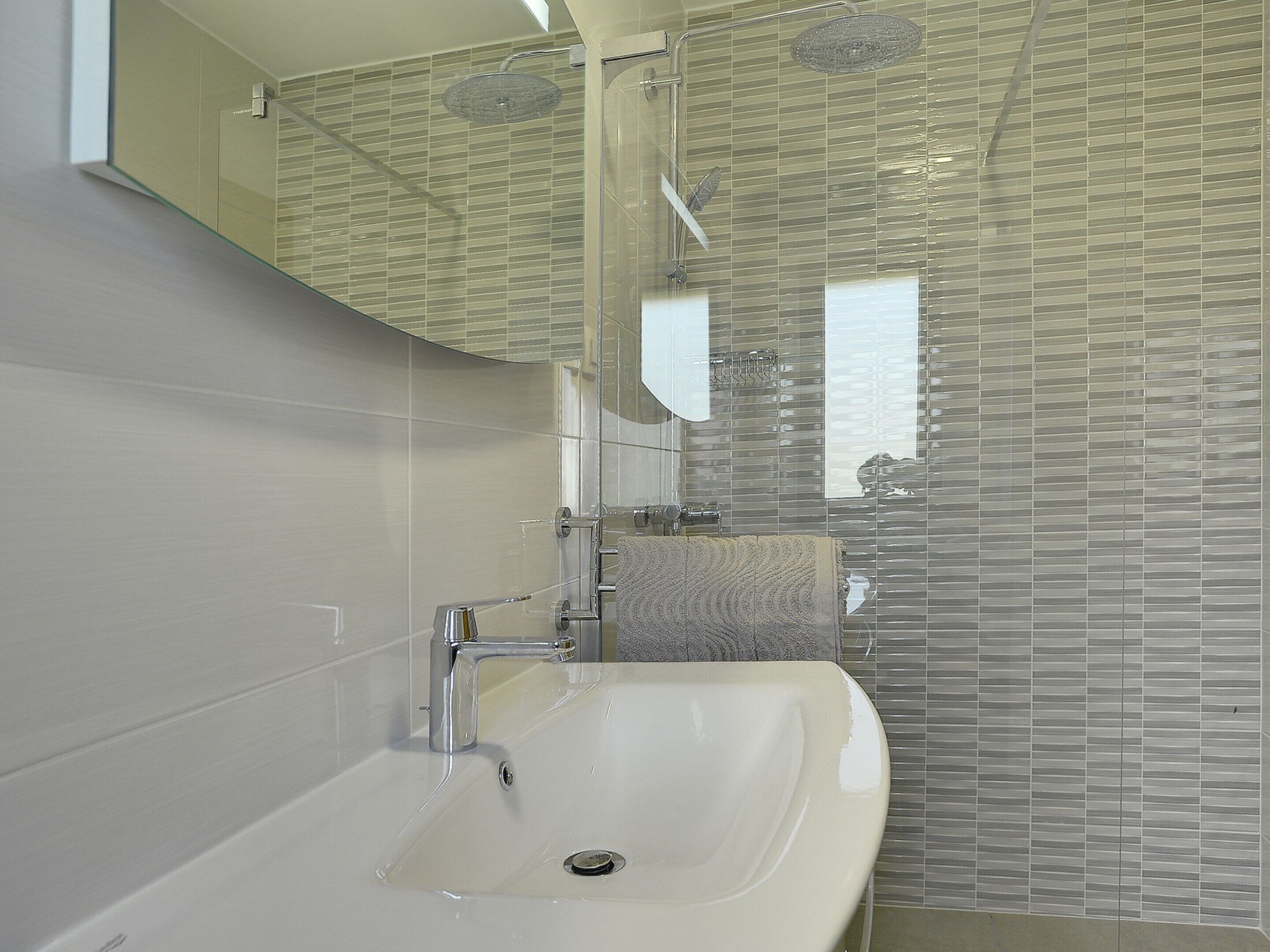 A modern bathroom with a bathtub, a sink, and a shower.