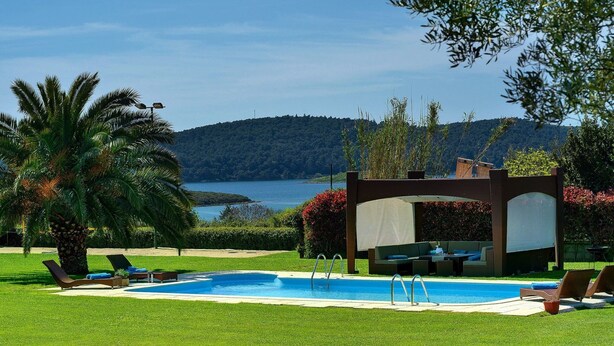 A pool area with lounge chairs, a pergola, and a view of a lake and hills. - Luxurious Villa in Pomer with Pool & Hot Tub (Medulin)