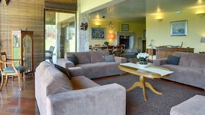 A spacious living room with a large sectional sofa, a wooden coffee table, and a fireplace. - Luxurious Villa in Pomer with Pool & Hot Tub (Medulin)