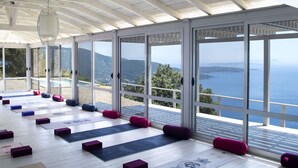 A spacious room with large sliding glass doors offering a view of the sea and mountains. - Modern Villa in Vasiliki with Swimming Pool & Hot Tub (Lefkada)