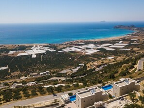 An aerial view of a coastal area with large industrial buildings, a road, and a beach in the distance. - Scenic Villa With Private Pool (Kissamos)