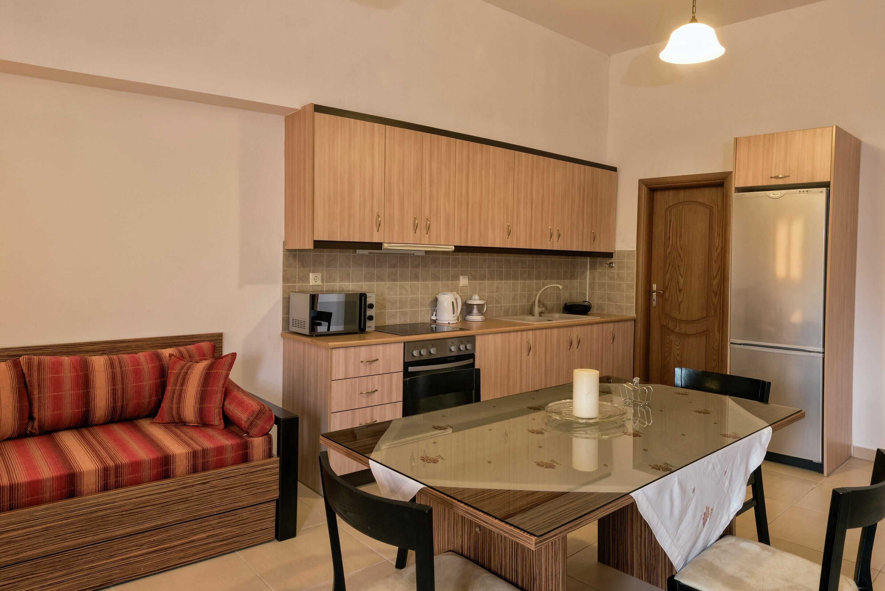A compact kitchen with wooden cabinets, a built-in microwave, a stove, and a refrigerator.