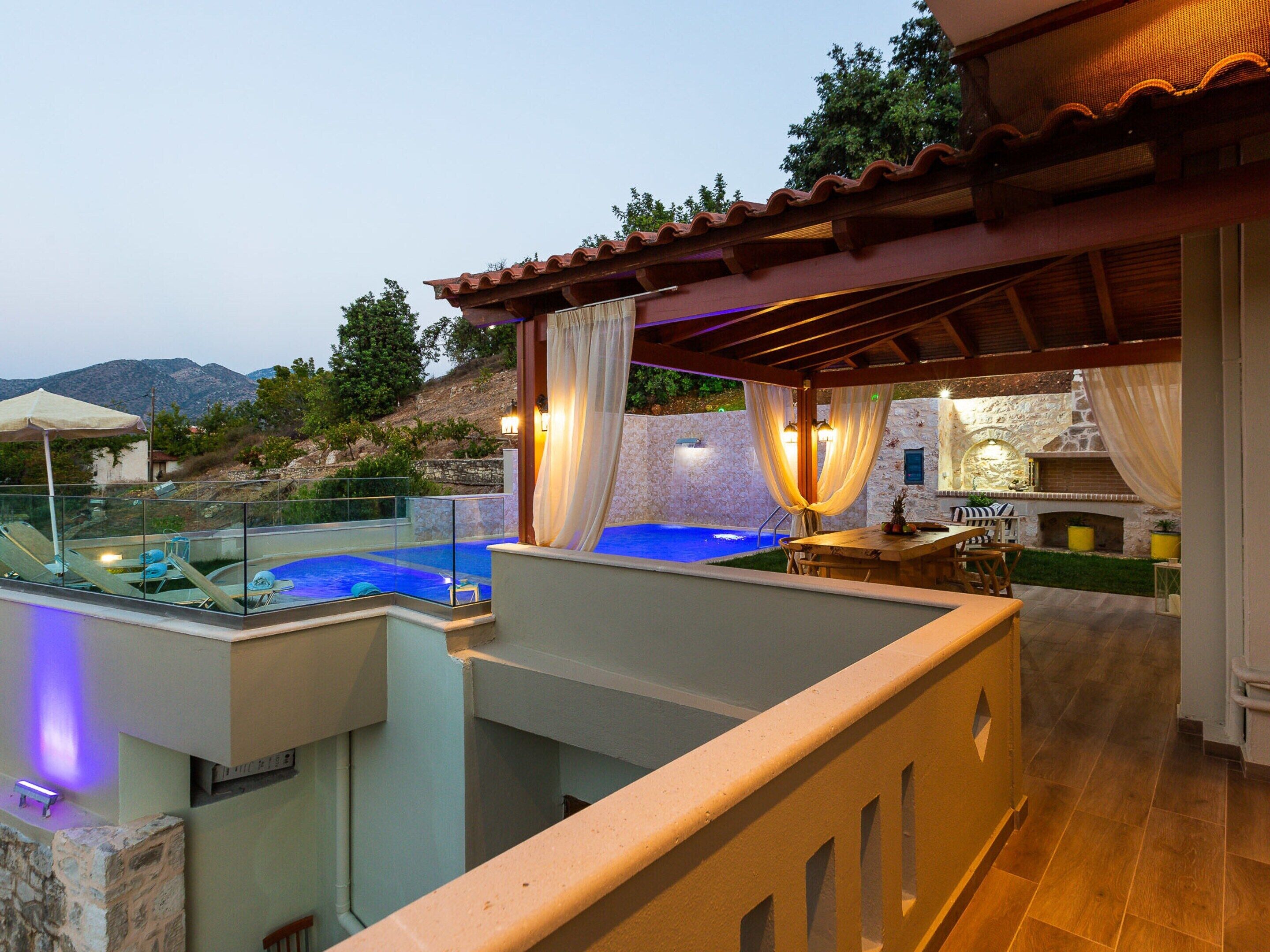 Zona de piscina en la azotea con pared y chimenea de piedra.