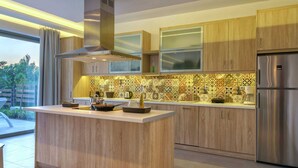 Eine moderne Küche mit Holzschränken, einer Edelstahl-Dunstabzugshaube und einer farbenfrohen Spritzschutzwand.