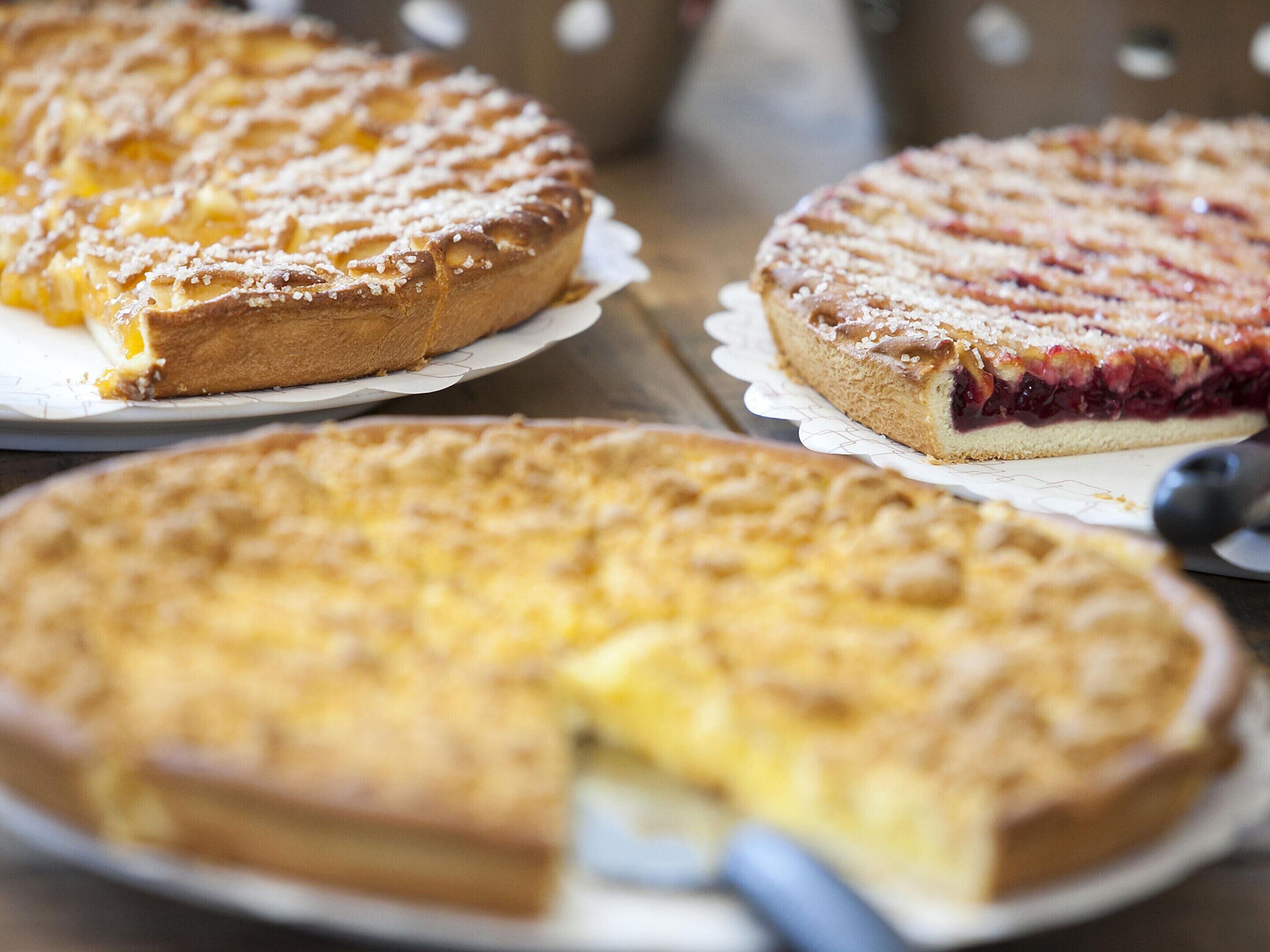 Três tortas em pratos com fundo de mesa de madeira.