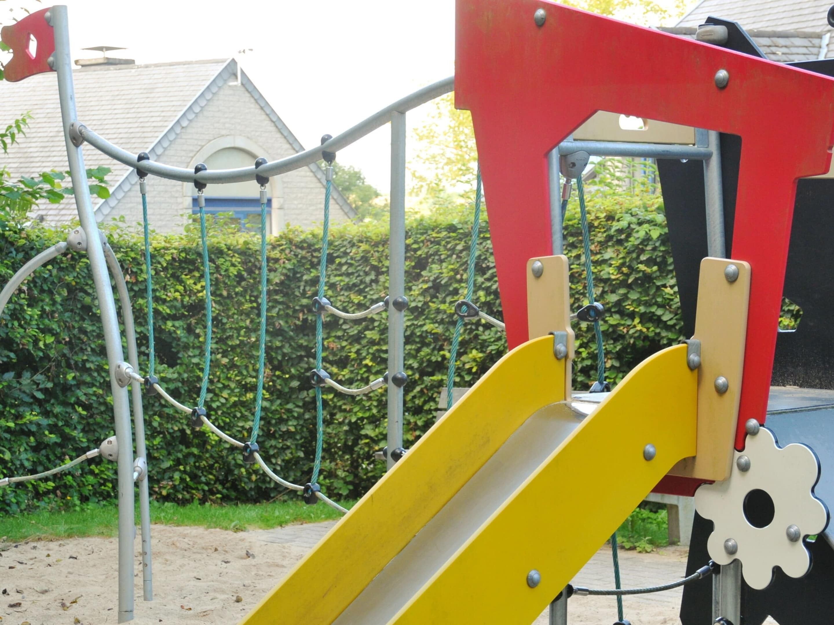 Ein Spielplatz mit Rutsche und Klettergerüsten.