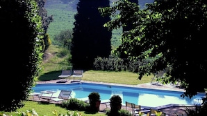 A rectangular swimming pool with a tiled deck, surrounded by a grassy area and trees. - Villa in Montemaggiore With Private Pool (Colli al Metauro)
