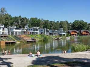 A lakeside resort with modern cabins, a sandy beach, and a calm lake. - Wooden Holiday Home with Microwave near Brunssummerheide (Brunssum)