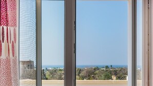 Un balcon offrant une vue dégagée sur la mer et les bâtiments situés au loin.