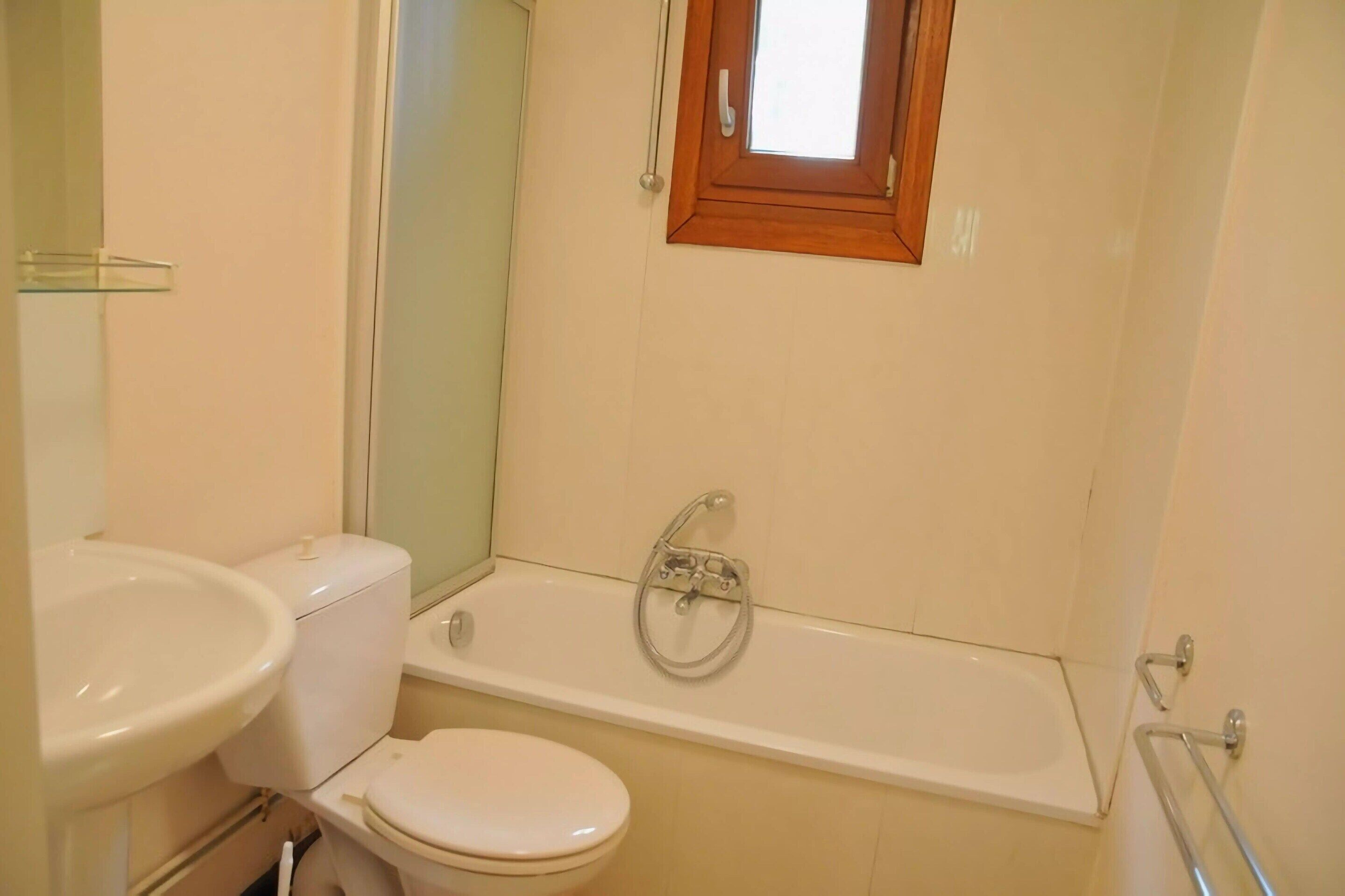 Un baño con inodoro, lavabo y bañera.