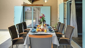 An outdoor dining area with a stone wall, wooden ceiling, and blue shutters. - Lovely Holiday Home With Private Pool (Svetvincenat)