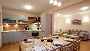 A modern kitchen with a dining area set for a meal, featuring a large table, chairs, and a sofa in the living room. - Beautiful Villa With Spacious Terrace and Private Swimming Pool, on the Croatian Island of Hvar (Hvar)