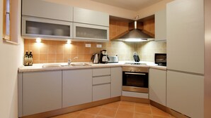 A modern kitchen with white cabinets, a built-in oven, a coffee maker, and a sink. - Beautiful Villa With Spacious Terrace and Private Swimming Pool, on the Croatian Island of Hvar (Hvar)