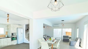 A spacious living area with a dining table, chairs, and a kitchen area with modern appliances. - New Beautiful Villa With Private Pool at Coastal Area Just Outside Rethymno, NW (Apokoronas)