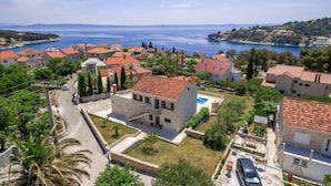 A coastal village with traditional stone houses, a clear blue sea, and a road leading into the village. - Villa in Sumartin Near the Beach & Ferry Port (Selca)