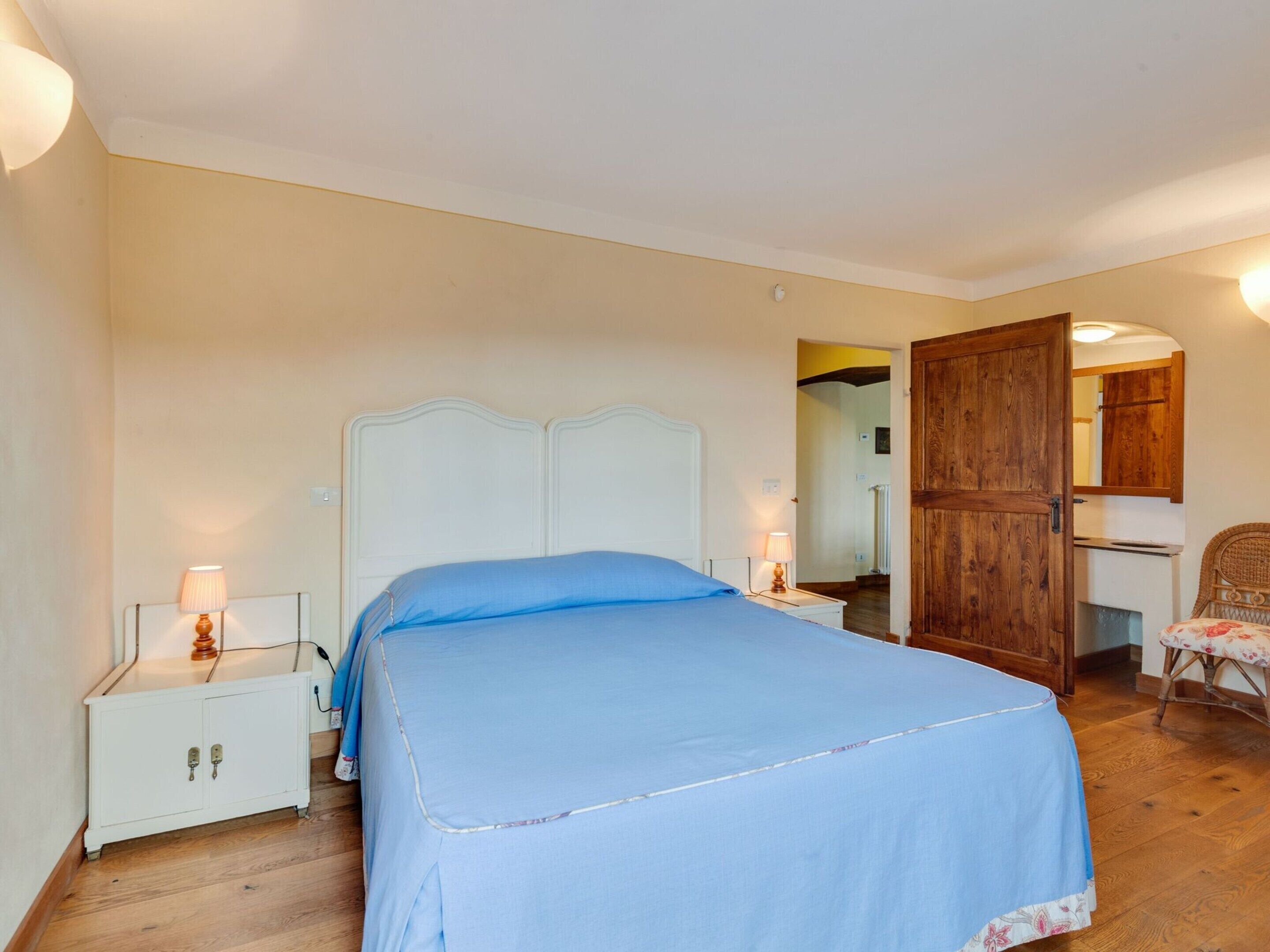 Una camera da letto con un letto, comodini, un armadio e una sedia.