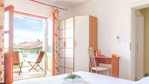 A bedroom with a bed, a desk, a chair, and a wardrobe. There is a balcony with a chair and a table. - Charming Villa With Spacious Rooms and Private Swimming Pool in the Lavender Island of Hvar (Hvar)