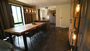 A modern kitchen with a wooden island, dark flooring, and pendant lighting. - Modern Apartment in Belgium With Bubble Bath (Durbuy)