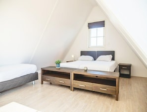 A bedroom with a bed, bedside tables, a small table with a plant, and a window. - Holiday Home Built in Zaanse Style, Near Alkmaar (West-Graftdijk)
