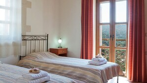 A bedroom with two beds, a nightstand with a lamp, and a window with curtains. - Dreamy Villa in Rethymnon With Private Pool (Rethymno)
