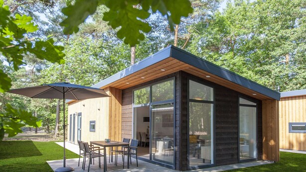 A modern wooden house with a patio, a dining table, and chairs. - Modern Lodge With Infrared Sauna, Near Helmond (Mierlo)