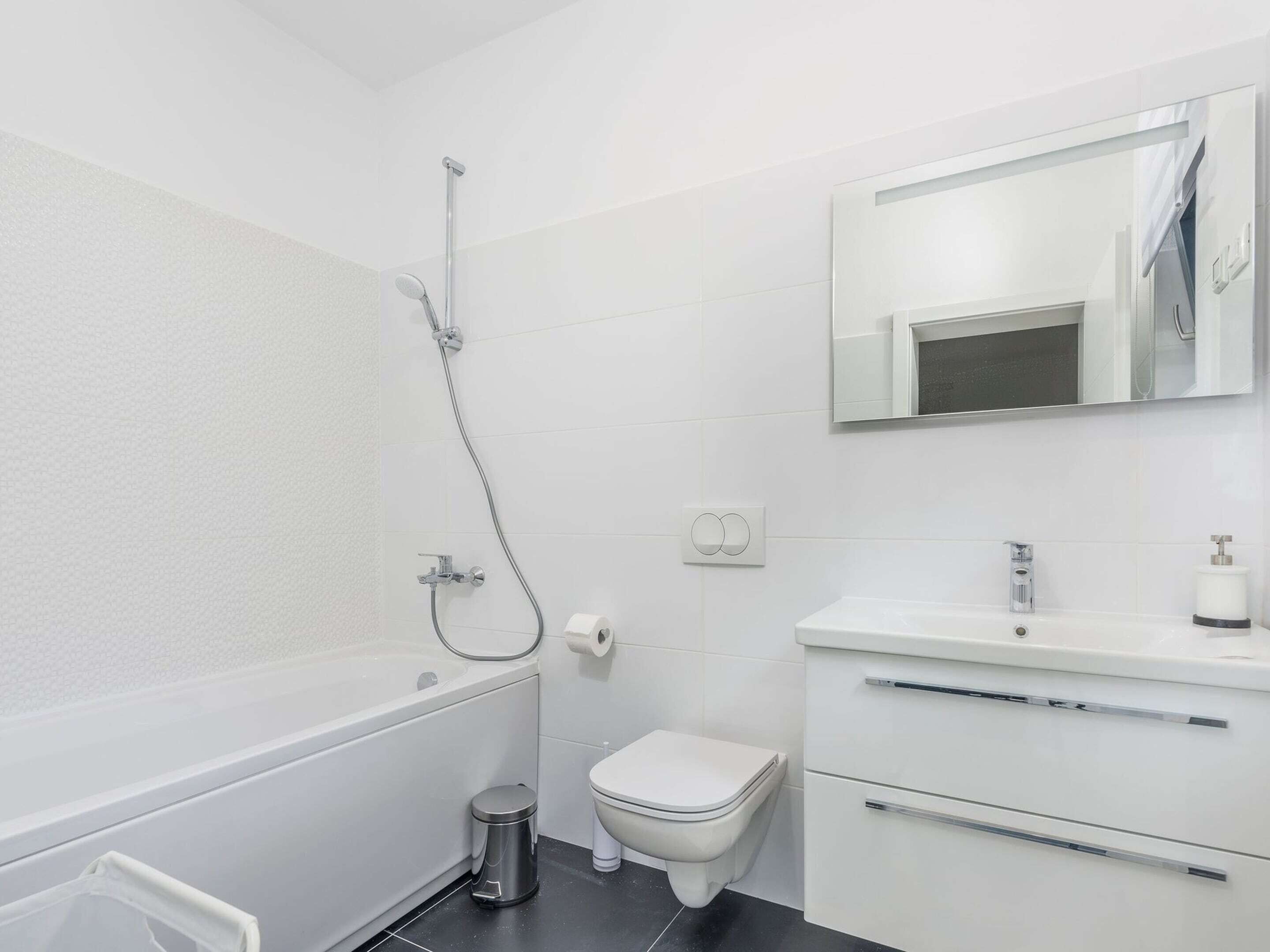 A modern bathroom with a bathtub, toilet, and sink.