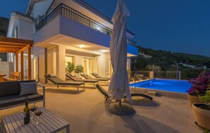 A modern villa with a swimming pool, outdoor seating, and a covered patio area. - Villa in Cres With Sea Views & Pool (Cres)