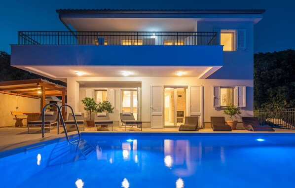 A modern two-story house with a swimming pool, outdoor seating, and a balcony. - Villa in Cres With Sea Views & Pool (Cres)
