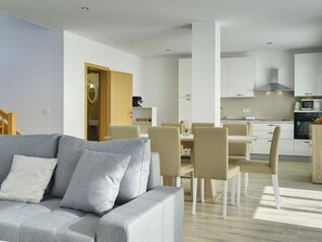A modern living room with a grey sofa, beige chairs, and a dining area with a table and chairs. - Comfortable House With Large Garden and Terrace, Near the Beach (Vodnjan)