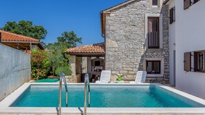 A stone building with a swimming pool, outdoor seating, and a stone facade. - Villa in Istria With Pool Near Croatian Sea (Svetvincenat)