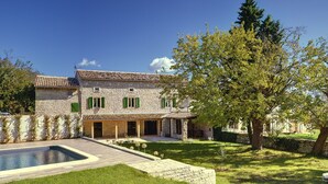 A stone house with a swimming pool, green shutters, and a well-maintained lawn. - Spacious Holiday Home in Svetvincenat With Pool (Svetvincenat)